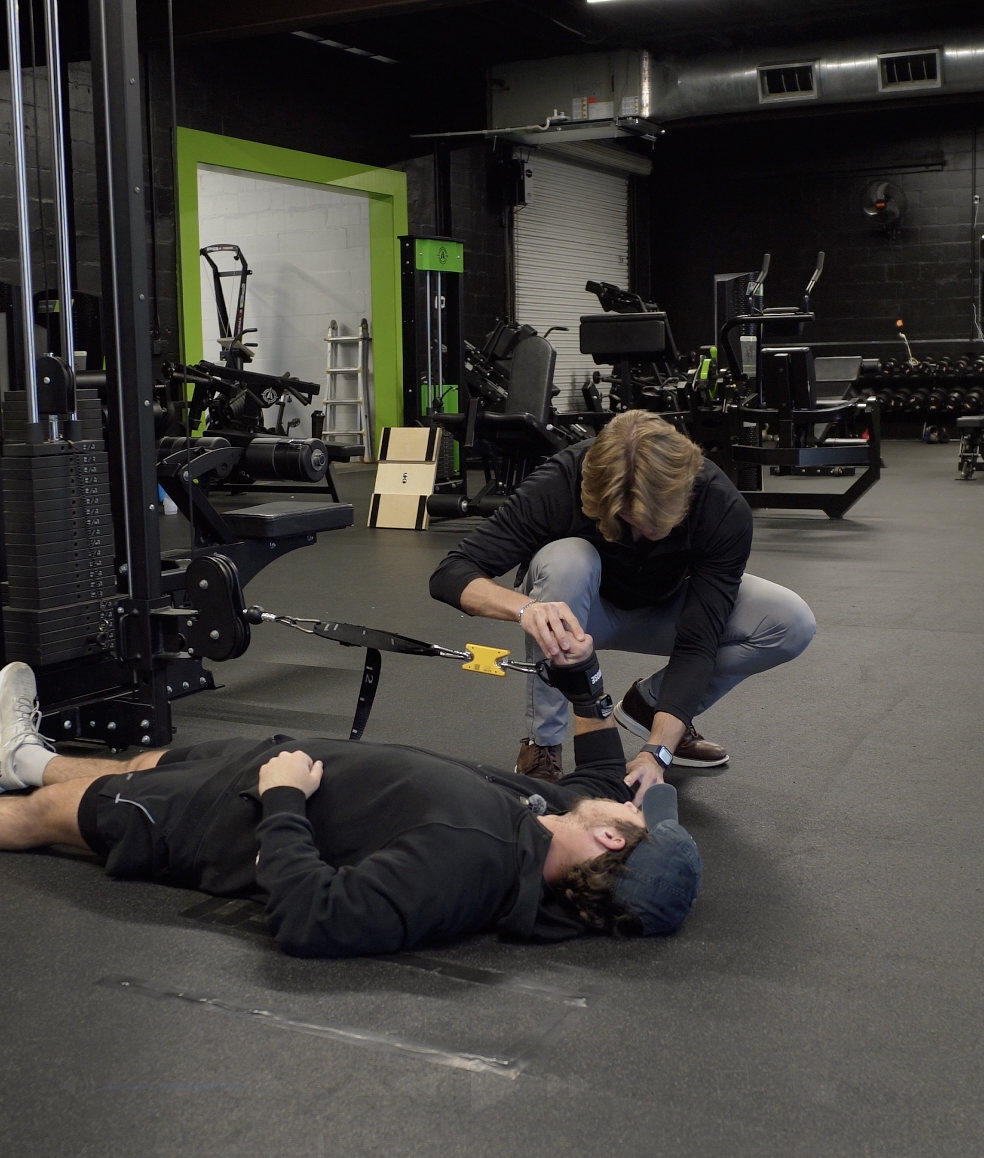Dr. Bokash performing isometric shoulder external rotation testing using the Tindeq Progressor at Empire Gym